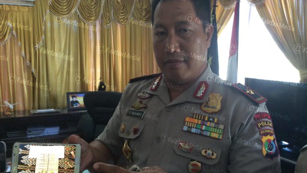 General Endang Sunjaya, police chief of Nusa Tenggara Timur province shows a mobile phone with a picture of the money on Tuesday.