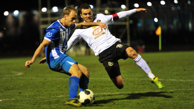 Right, Dustin Wells of Gungahlin United FC attempts to tackle Brayden Sorge of Sydney Olympic FC.