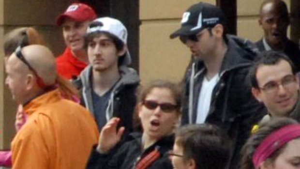 A photo shows the two accused bombers, brothers Dzokhar (left, in white cap) and Tamerlan (right, in black cap) Tsarnaev behind barriers on the marathon route on April 15, 2013.