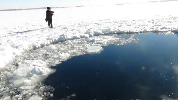 A circular hole in the ice where a piece of asteroid debris reportedly struck a lake near Chelyabinsk, about 1500 kilometres east of Moscow, in February 2013.
