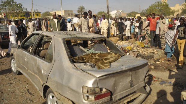 People gather at the site of a bomb explosion in Nigeria's second-largest city, Kano, in November last year. 