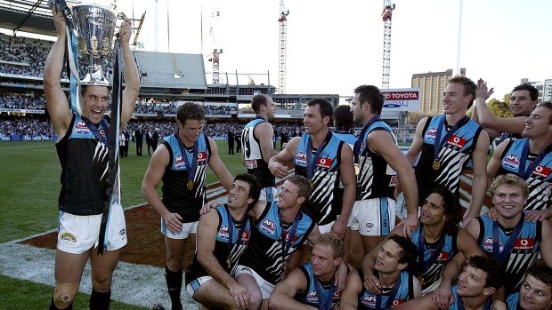 Port Adelaide captain Warren Tredrea holds the premiership cup aloft after his team defeated the Brisbane Lions in the 2004 grand final, the first time two non-Victorian teams have figured in the event.