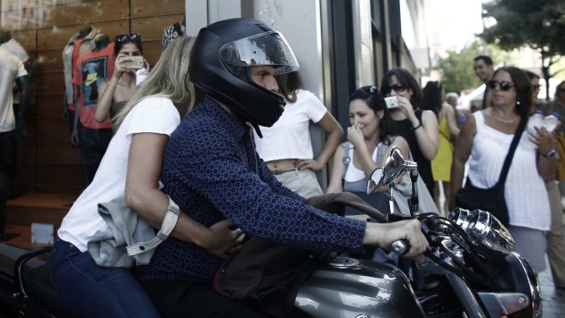 Varoufakis leaves the Greek finance ministry on his motorbike with his wife.