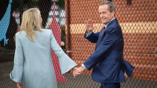 Opposition leader Bill Shorten, with wife Chloe, waves to media after voting in his electorate of Maribyrnong on Saturday.