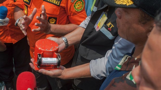 A member of National Transportation Safety Committee holds the flight data recorder from the crashed Lion Air jet.