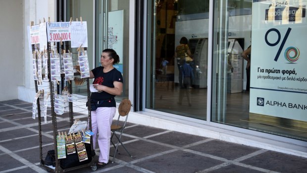A vendor sells lottery tickets outside a bank in Athens on Friday. More discussions over Greece's third bailout in five years are set to begin in Athens imminently.