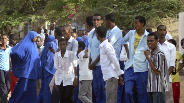 Students gather and watch from a distance outside the Garissa University College after an attack by Islamist gunmen.