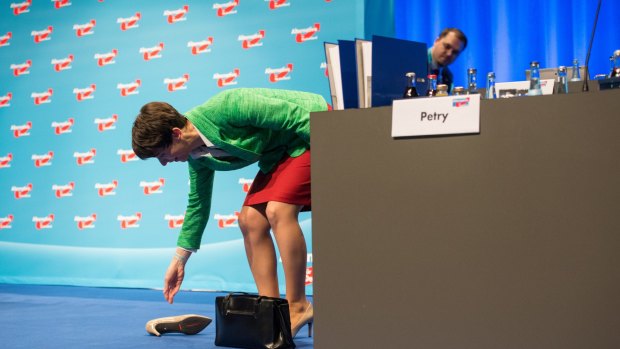 Head of the Alternative for Germany party Frauke Petry collects her shoe after stumbling during their convention.