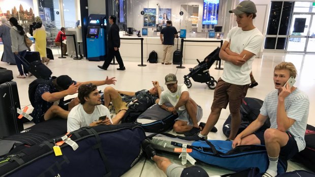 A group of surfers from Sydney wait for updates on their cancelled flight to Sumatra.