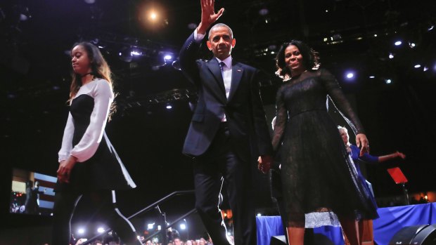 President Obama waves on stage with first lady Michelle Obama, daughter Malia, after the presidential farewell address.