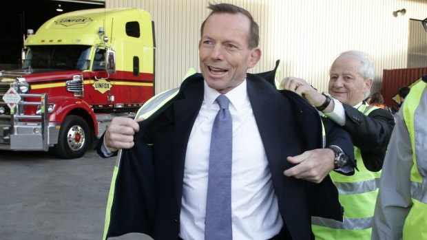 In better times: Philip Ruddock helps then Opposition Leader Tony Abbott with his high vis vest in West Melbourne in 2013. 