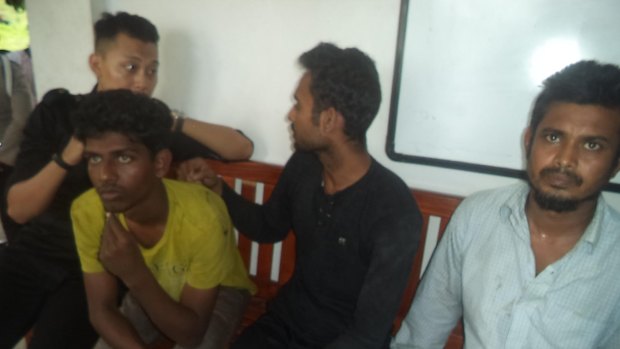 Three Bangadeshi nationals wait at the East Nusa Tenggara water police office after being returned to Indonesia.