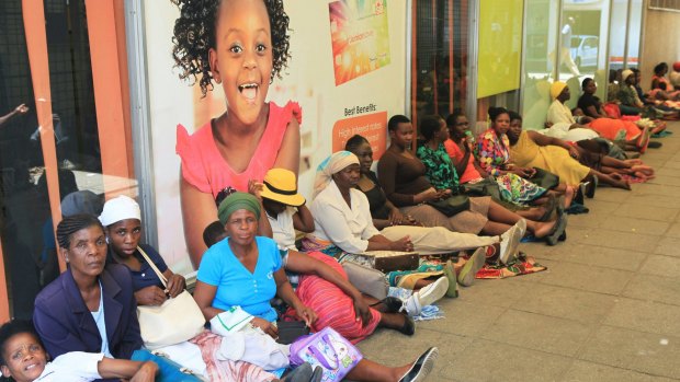 Women wait in a bank queue in Harare.