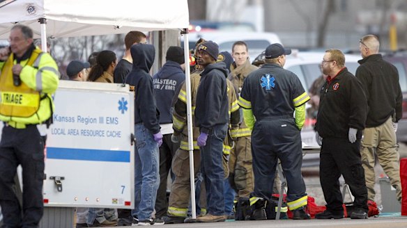 Workers gather near Excel Industries after the shooting. 