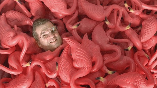 Don Featherstone, creator of the original pink flamingo, sits surrounded by many of the plastic creatures in this file photo taken in 1998.