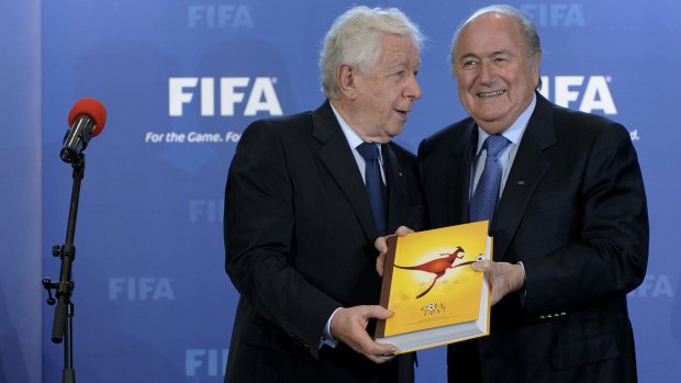 Frank Lowy presents Sepp Blatter with the official bid document in 2010. 