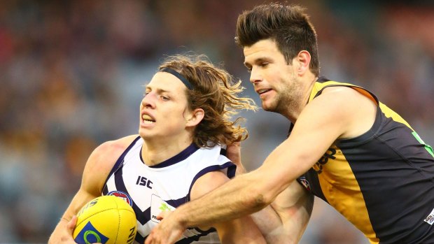 Out of grasp: Nathan Fyfe slips clear of Trent Cotchin.