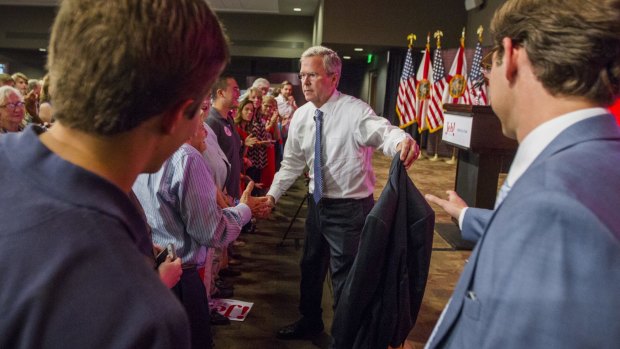 Republican presidential candidate Jeb Bush hands off his coat as he approaches supporters on Monday.