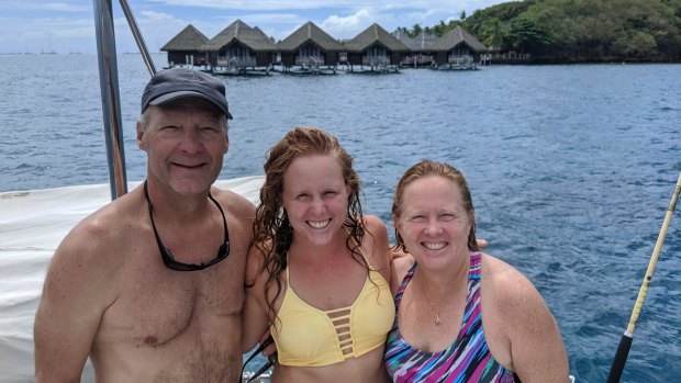 Kristen Pankratz, center, poses with her parents David and Anne on their yacht Amazing Grace in Tahiti.