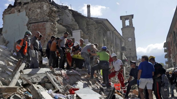 Rescuers carry a stretcher following an earthquake in Amatrice, Italy.