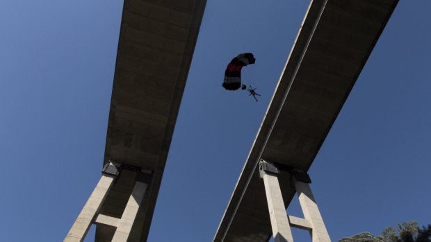 A BASE jumper launching off a bridge at Douglas Park.