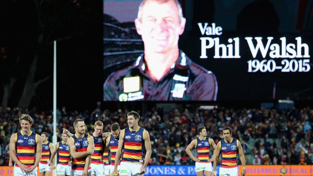 Flood of emotion: Adelaide players walk from the field after round 16, as a tribute is paid to coach Phil Walsh. 