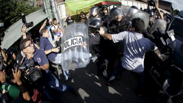 Riot police officers confront the media surrounding former Guatemalan vice-president Roxana Baldetti in Guatemala City on Tuesday. 