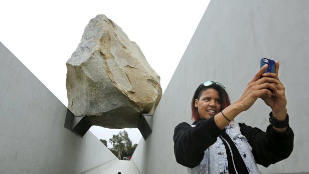 Monica Carter of Chicago takes a selfie in front of Michael Heizer's Levitated Mass boulder sculpture at the Los Angeles County Museum of Art.