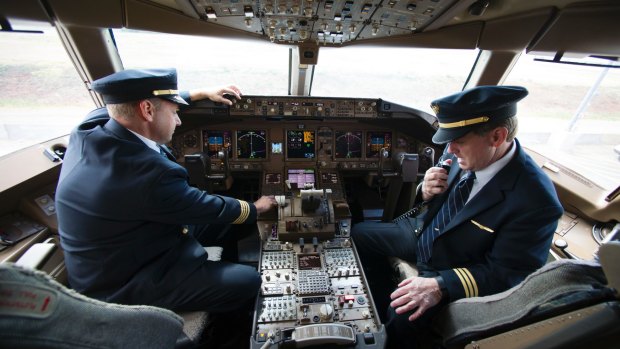 United Airlines Captain Tommy Holloman, left, and Captain Chuck Stewart, in the cockpit of an United Airlines Boeing 777 at Dulles International Airport.