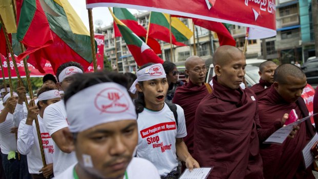 Nationalists wearing T-shirts that say "Stop Blaming Myanmar" and "Boat People are not Myanmar" and Buddhist monks march in a protest rally in Yangon.