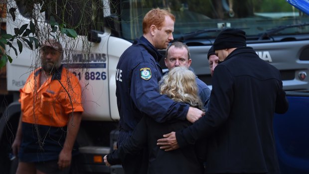 Detectives embrace Matthew Leveson's parents Mark (second right) and Faye (third left) after locating the possible burial place of their son Matthew Leveson in the Royal National Park.