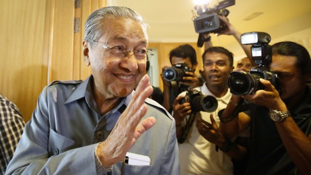 Former Malaysian prime minister Mahathir Mohamad waves to photographers after a press conference in Putrajaya on Monday. 