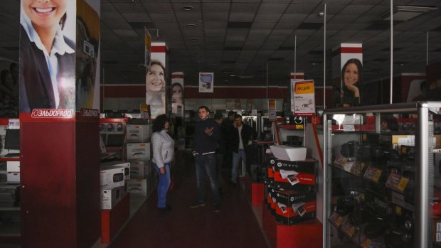 Customers stand in an electronics store in Simferopol, Crimea after the first two power lines were cut on Friday.