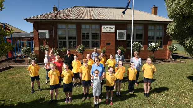 End of an era: The last students, with teachers and parents, at St Michael's primary school at Springbank, east of Ballarat, which is closing after 146 years on Friday. Principal Michael Kennedy at rear centre.