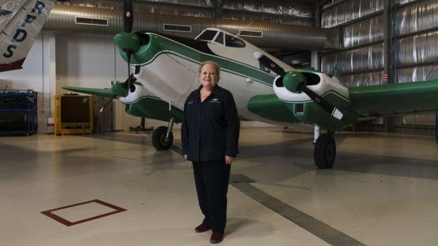 Sue Williams, from the Royal Flying Doctor Service Broken Hill visitor experience, with the service's first single-wing, three engine aircraft from the 1950s, on permanent loan from the Powerhouse Museum.