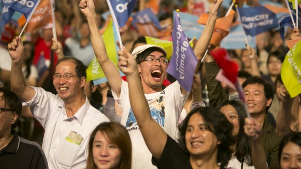 Supporters of independent opposition candidate Ko Wen-je celebrate after he won the mayoral elections for Taipei, part of a landslide defeat for Taiwan's ruling Kuomintang party.
