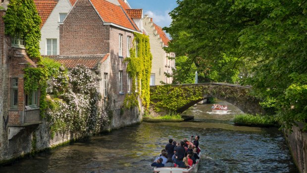Tourist boat on Canal Groenerei in the medieval city of Bruges.
