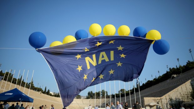 A giant European Union flag emblazoned with the greek word 'Nai' (Yes) flys above the Olympic stadium at a rally before Sunday's referendum.