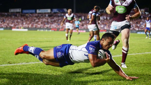 Attack Dogs: Sam Perrett of the Bulldogs dives over for the first try of the match.