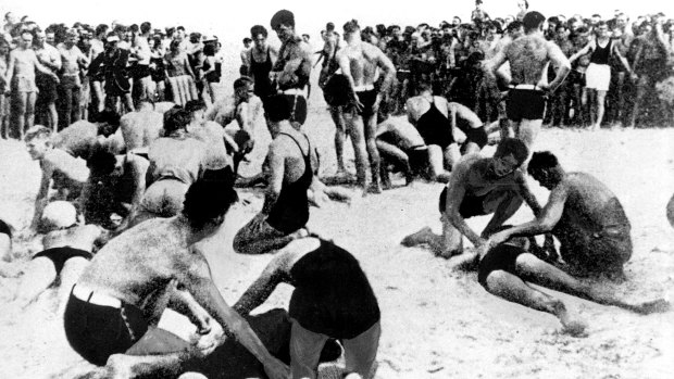 Exhausted bathers being revived by lifesavers on Bondi Beach, 6 February 1938.