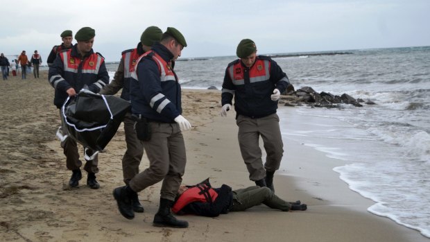 Turkish paramilitary police officers collect the body of a refugee lying on the beach in Ayvalik. 35 bodies have been found by authorities after the latest boat disaster.