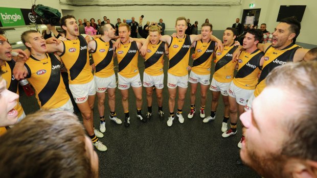 Richmond players sing the club song in the rooms after their win.