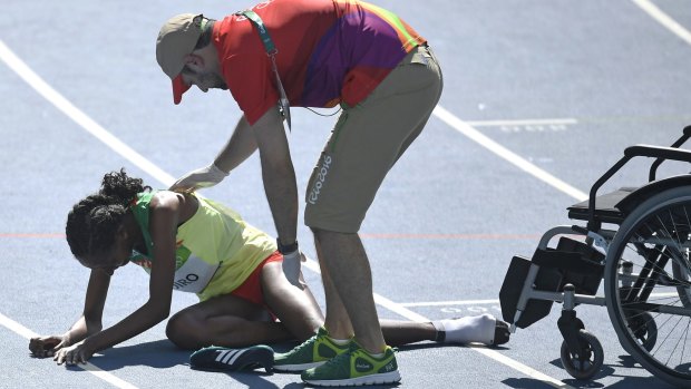 Ethiopia's Etenesh Diro is assisted by officials.