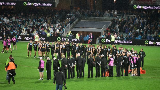 Port Adelaide and Collingwood players pay tribute to the late Phil Walsh after the last of the Thursday night games for season 2015. 
