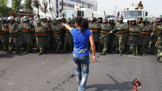 An Uighur woman protests in front of policemen in Urumqi in 2009.