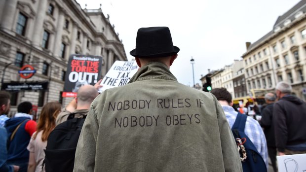 Protesters march during an anti-austerity demonstration in London after the opening of parliament.