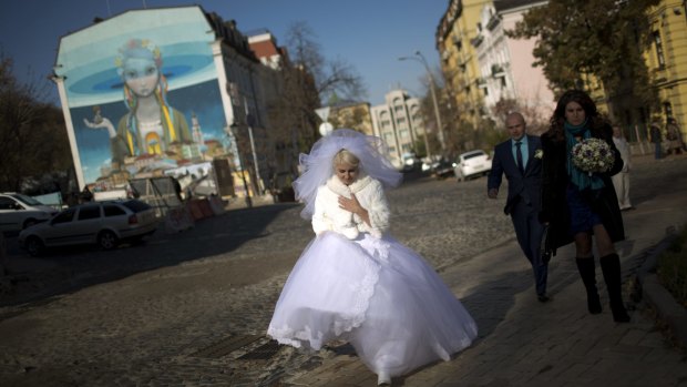 High hopes: A wedding party walks down the street in Kiev on Saturday.