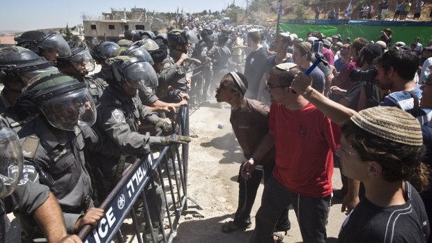 Israeli paramilitary police confront settlers protesting the demolition of buildings in the Israeli-occupied West Bank.