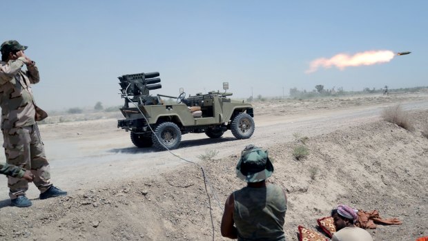 Shiite paramilitaries launch a rocket north of Fallujah in Iraq.