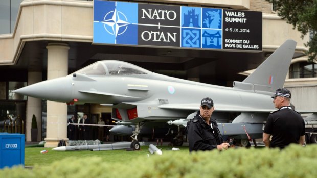 Police officers stand near a model of a Typhoon fighter jet ahead of the NATO summit in Wales last year.